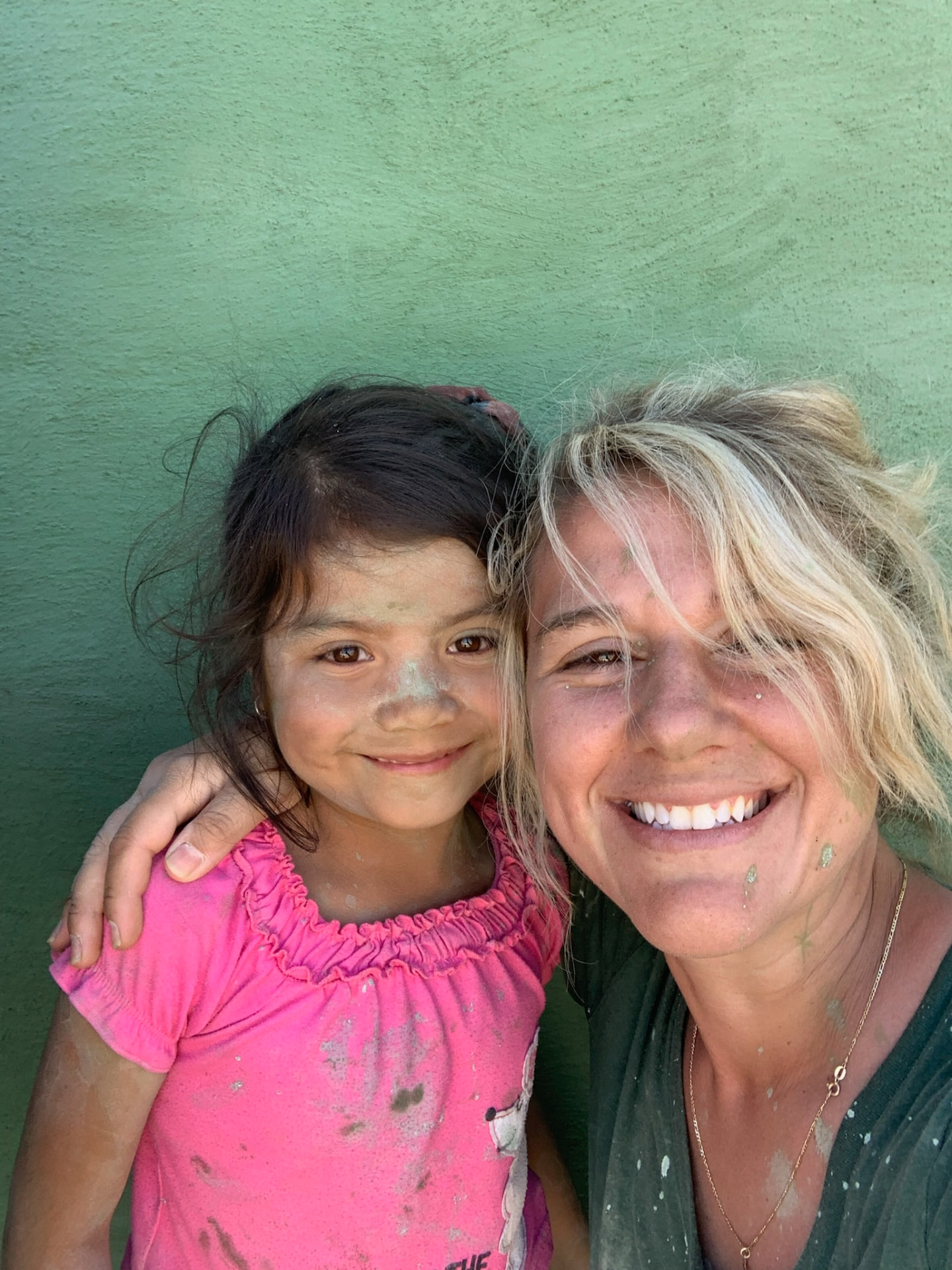 Smiling with a child covered in paint